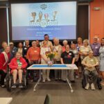 Group of individuals standing with Alice in Dairyland at a memory cafe held in a library