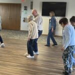 Photo of a group of memory café attendees dancing.