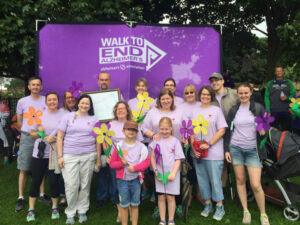 A group of people posing in front of a banner for Walk to End Alzheimer's