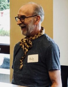 An older man with glasses and a fun bandana around his neck