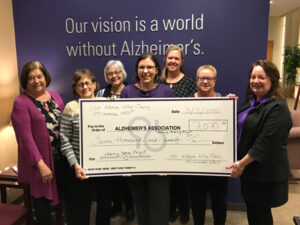 A group of people holding a giant check for the Alzheimer's Association