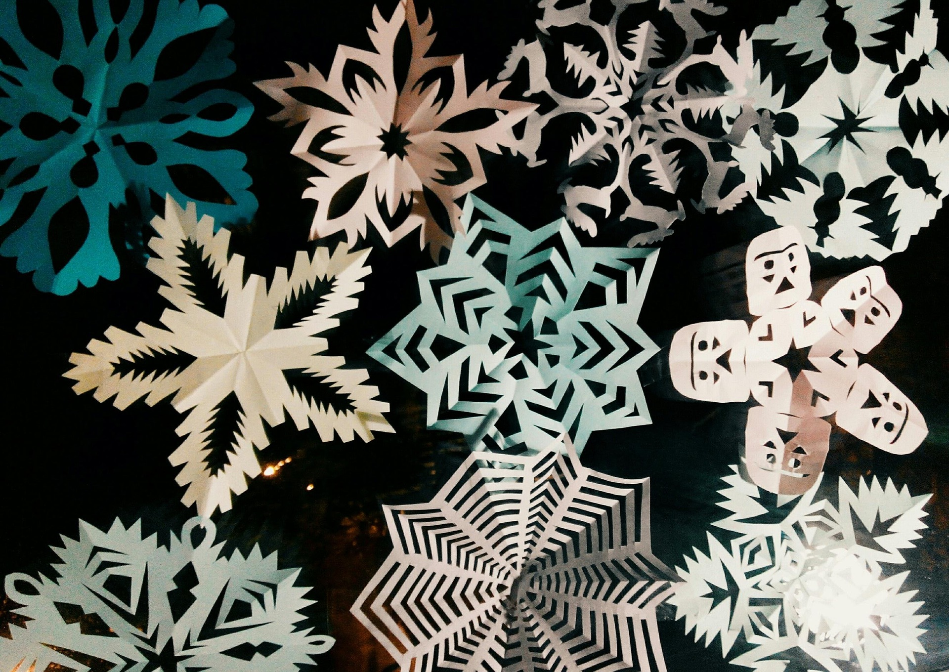 Various paper snowflakes against a black background