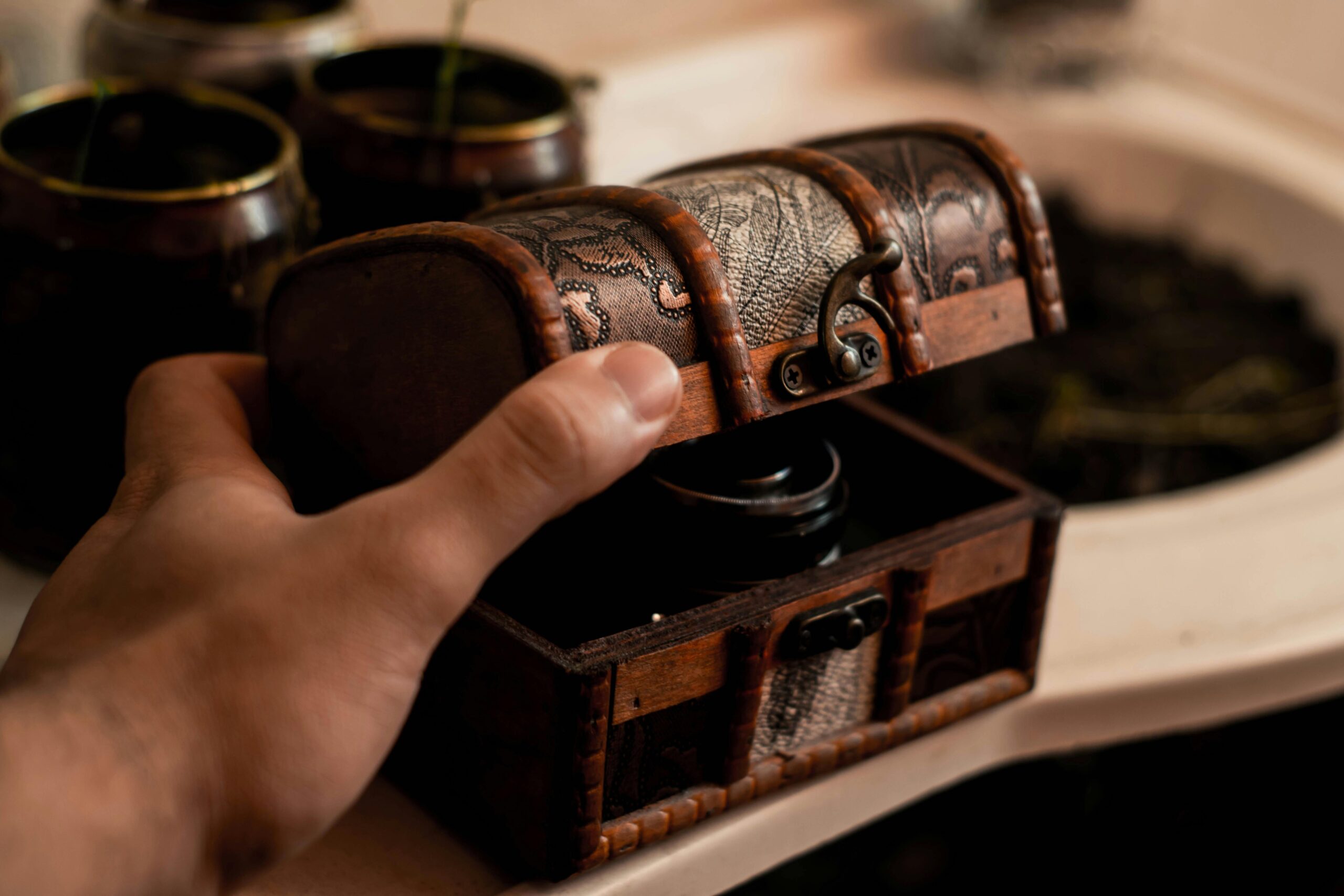A hand opens a decorated treasure chest.