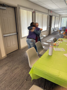 Two people embrace at a Memory Cafe.