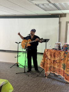 A man with a guitar performs at a memory cafe.