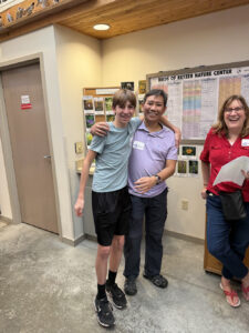 A young man has his arm around a man who looks to be his father.