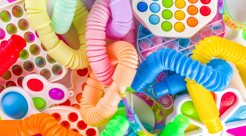 A pile of brightly colored plastic tubing and popper fidget toys