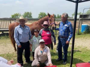 a family poses in front of a horse
