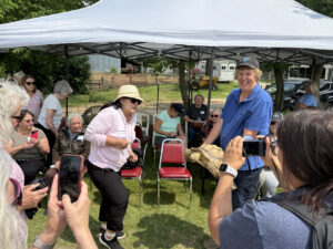 A zoo worker in a blue polo shirt holds a turtle for others to enjoy