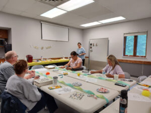 A small group of people work on activities at a Memory Cafe.