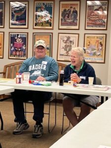 A man in a blue Badger ferry shirt smiles at the laughing woman next to him.