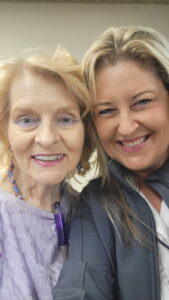 Two women smile at the camera for a selfie.