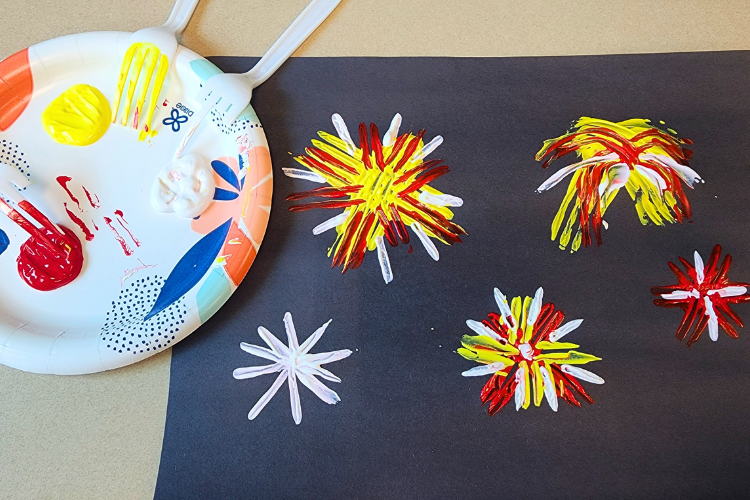A painting craft that involves using a fork to make fireworks on construction paper
