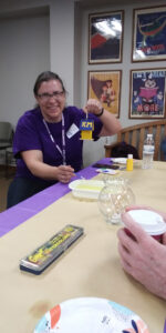 A volunteer worker shows the birdhouse she painted with the initials KM.