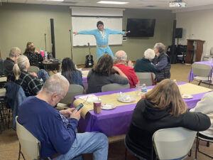An Elvis impersonator shows off some moves in front of an audience.