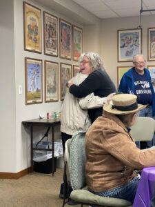 To people embrace at an event for the Library Memory Project.