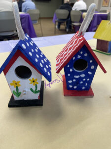 Two patriotic bird houses show off the red, white, and blue in colorful patterns.