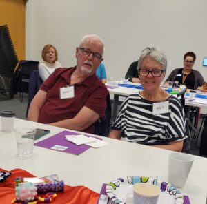 Two participants seated a table and smiling
