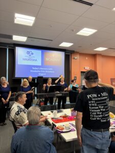 Broadway singers sing a patriotic song while a military veteran stands